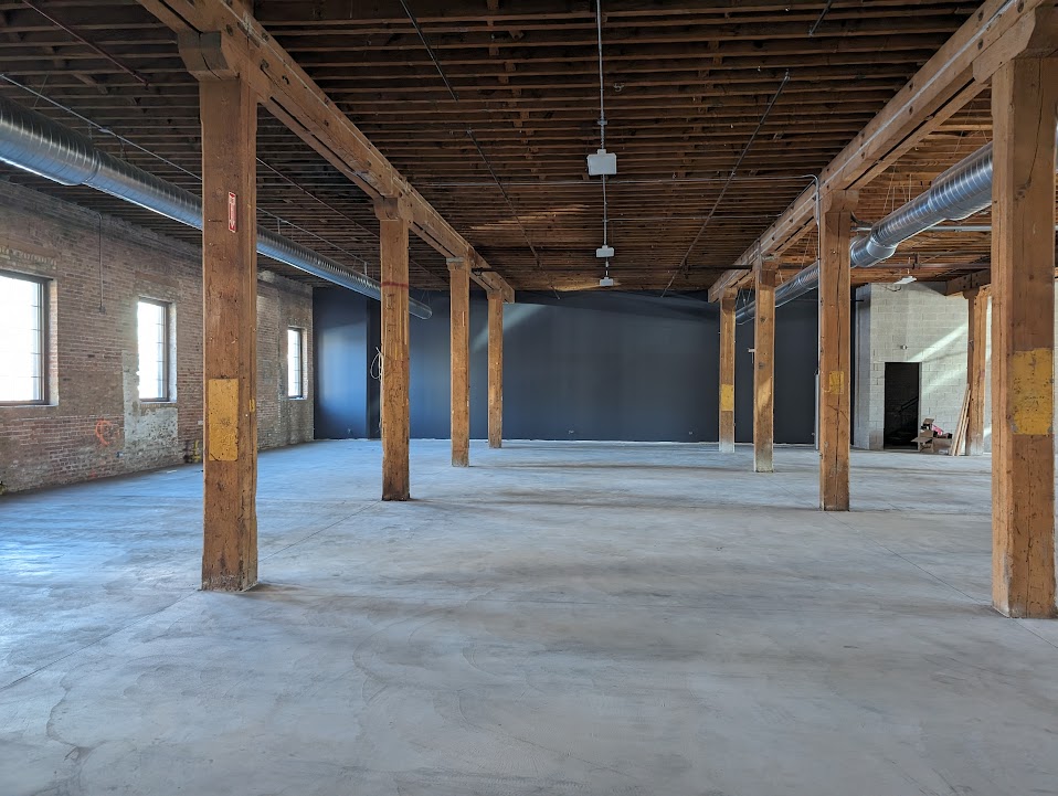 Commercial build-out open floor plan with exposed timber columns and polished concrete