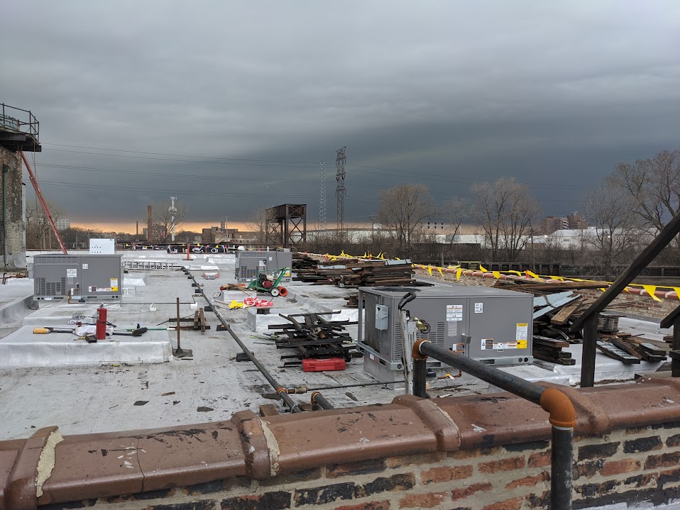 Commercial rooftop during demo phase with existing HVAC units