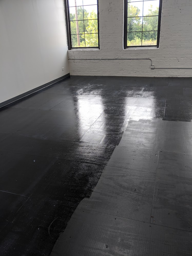 Polyurethane floor finish in artist studio with exposed brick and industrial windows
