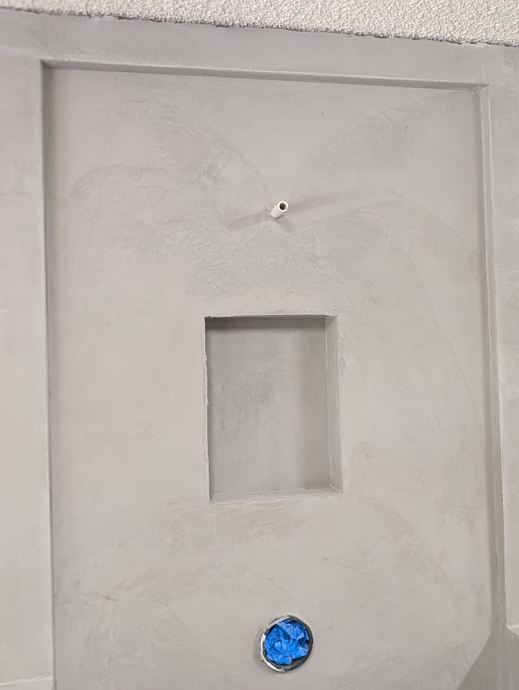 Close-up of microcement shower niche with seamless finish detail