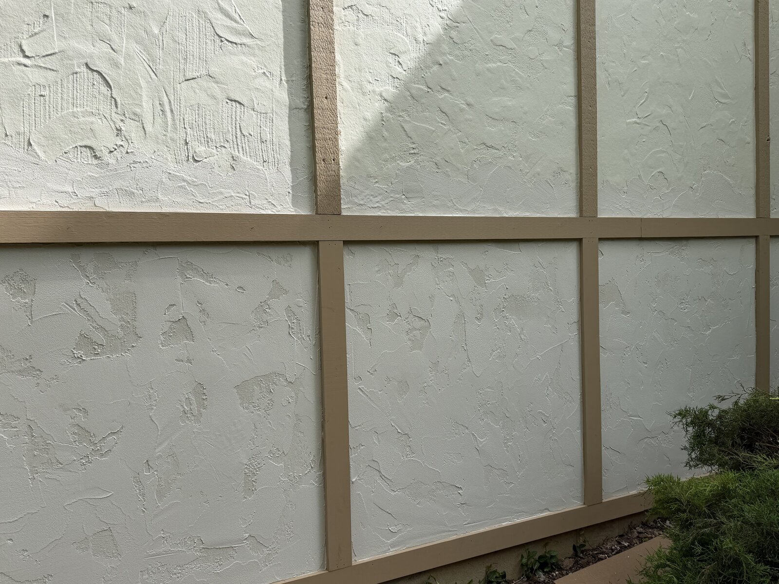 Freshly repainted board-and-batten stucco exterior wall