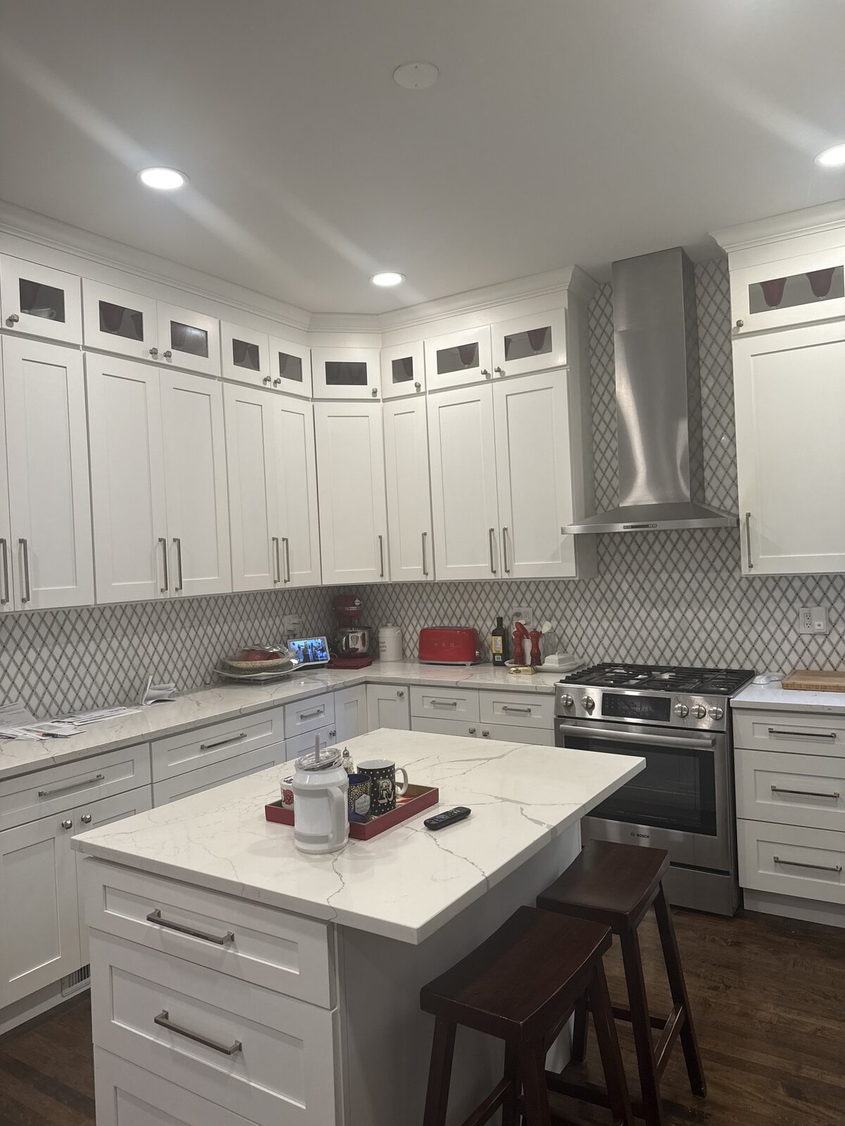 Remodeled kitchen with stainless range hood, quartz island and breakfast bar seating
