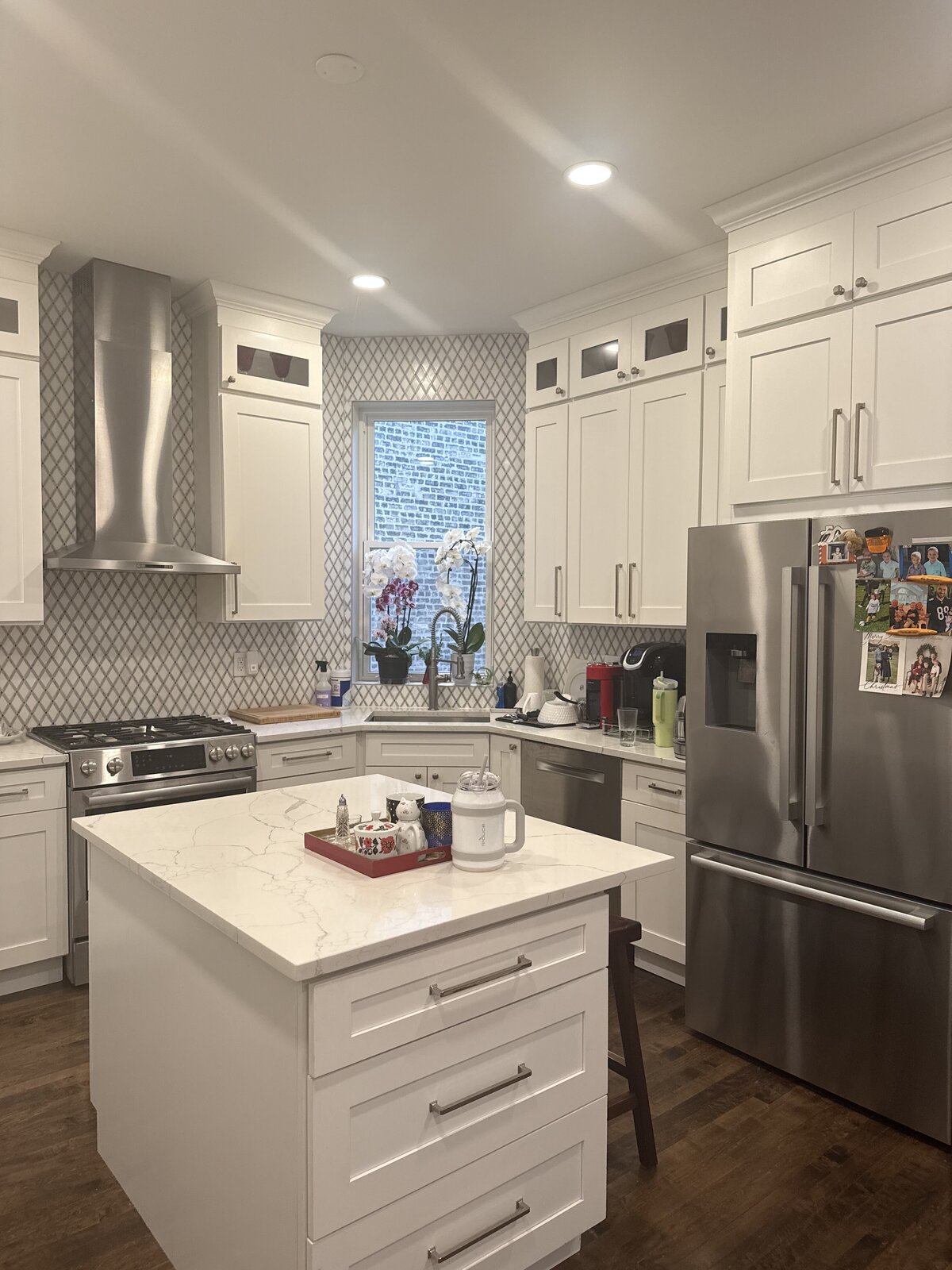 Finished white shaker kitchen with quartz waterfall island and stainless appliances
